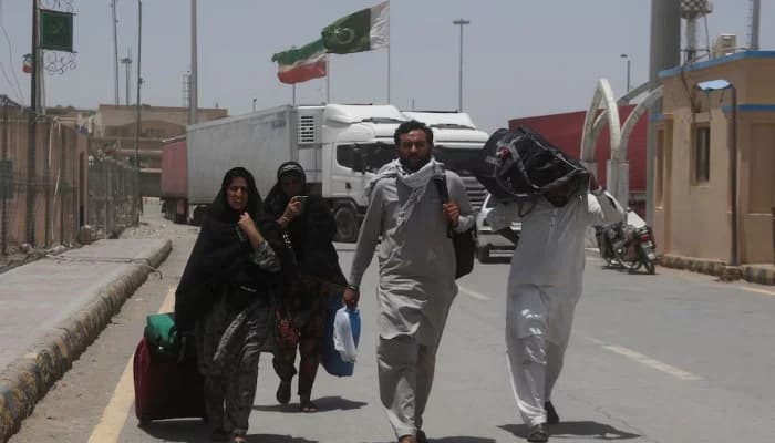 Pakistani pilgrims walk with their belongings after they returned from Iran, following the Israeli strikes in Iran, at the Pakistan-Iran border crossing in Taftan, Pakistan June 19, 2025.
