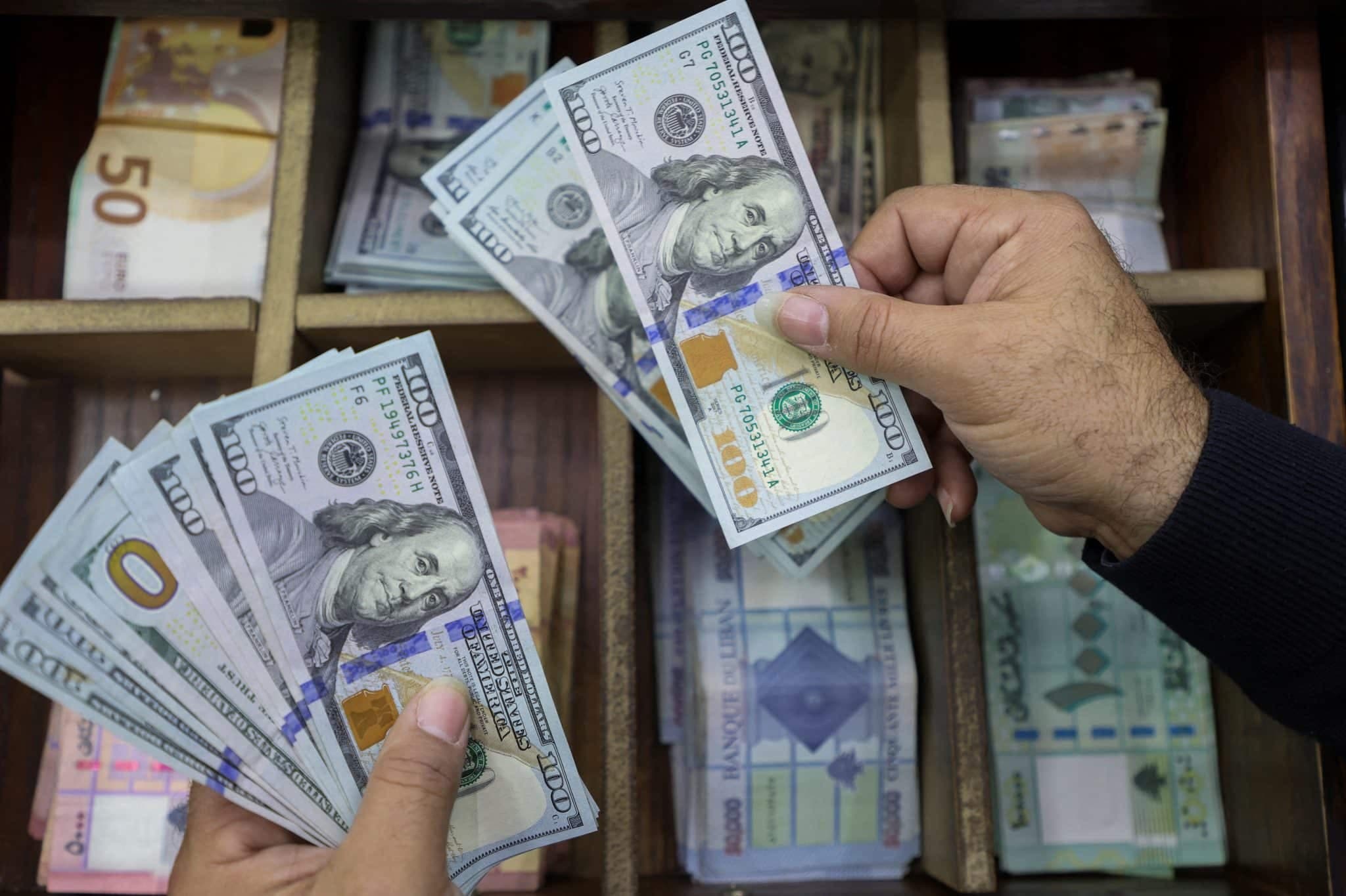 A money exchange vendor holds U.S. dollar banknotes at his shop in Beirut, Lebanon December 21, 2022.