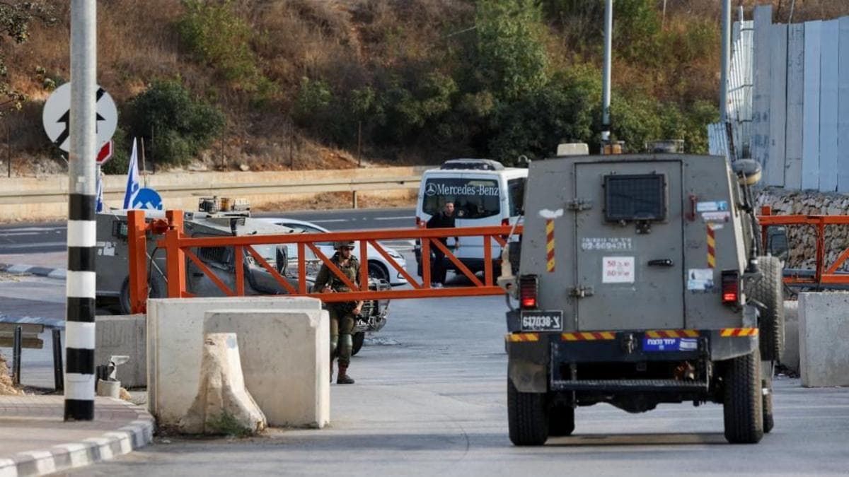 Image caption, An Israeli army vehicle passes near the closed entrance of Hebron, in the Israeli-occupied West Bank